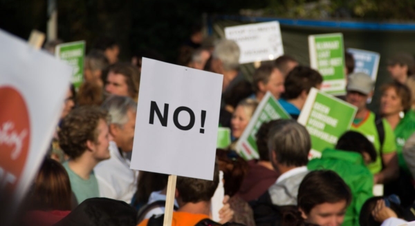 Photo of protesters holding a sign that says